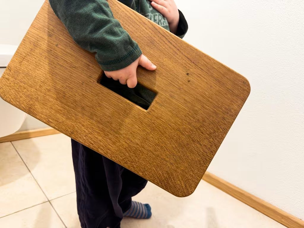 Hocker aus Eichenholz in den Händen eines Kindes