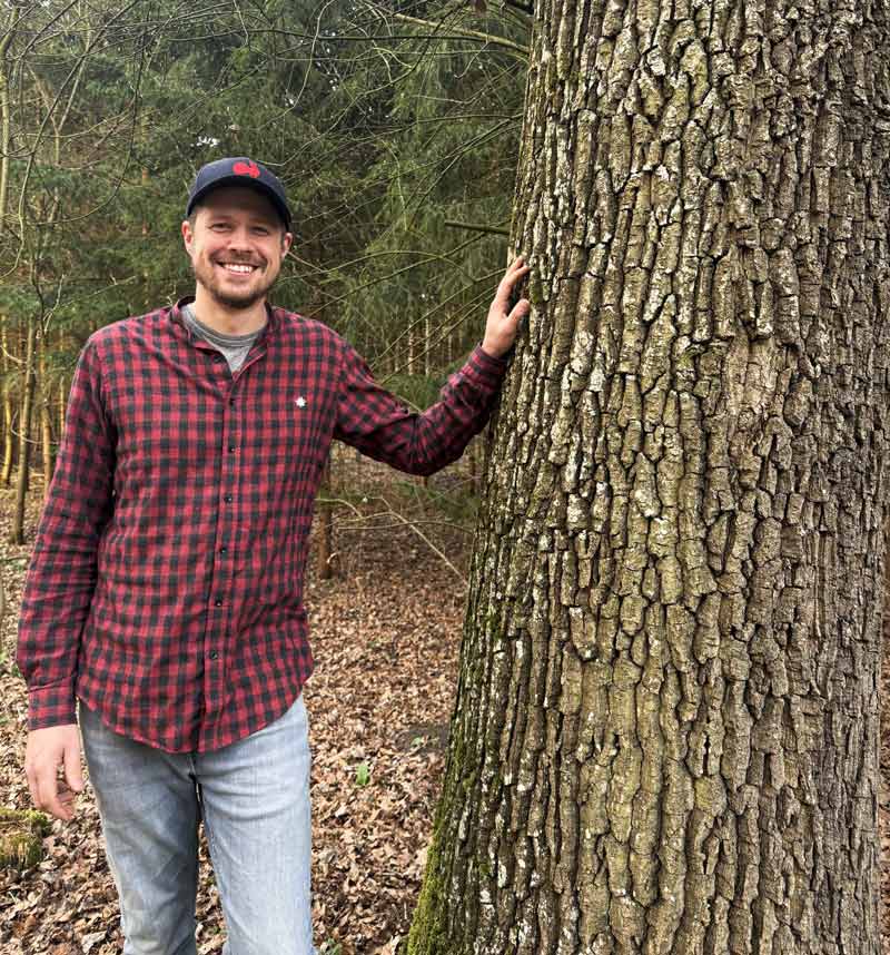Julian Madeja bei einem Baum im Wald bei nature crafts